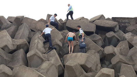 マカオ国際空港滑走路の護岸テトラポットに身を隠していた密航者の男＝9月3日（写真：澳門海關）