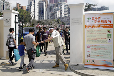 墓参りに訪れた市民らにデング熱予防に関するチラシを配布する衛生局スタッフ＝2018年4月5日、新西洋墳場（写真：GCS）