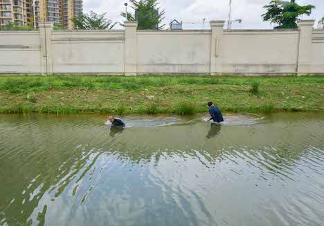 密入境者に扮してキャンパス外周の水路を進むマカオ税関職員＝2018年7月9日（写真：澳門海關）