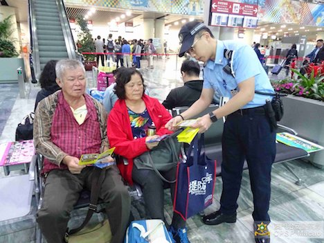 マカオ国際空港で機内スリに対する注意を呼びかける警察官（写真：マカオ治安警察局）