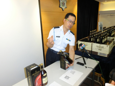 押収したニセ洋酒について解説を行う税関職員（写真：澳門海關）